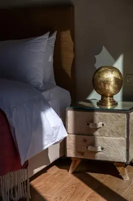 a bed with a nightstand with a goldigil on top of it at Villa Roseraie Isabella in Marrakech