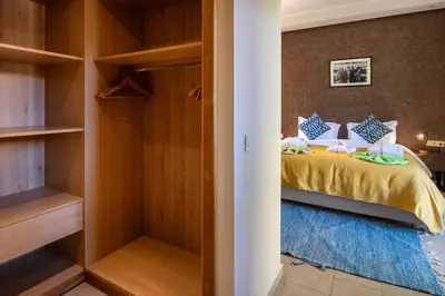 a bedroom with a bed and a closet at Villa Roseraie Isabella in Marrakech