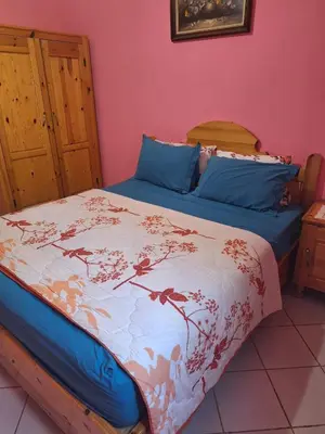 a bedroom with a large bed with blue pillows at Maison Touria in Ouzoud