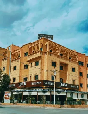 a tan building with a sign on top of it at Residence Chay - Appartement de luxe in Ouarzazate