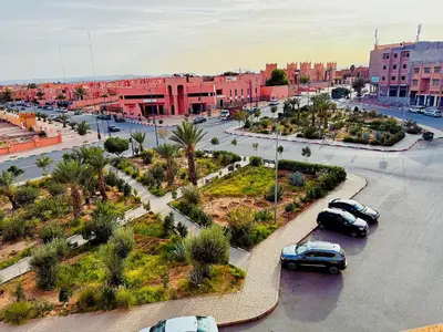 two cars parked in a parking lot in a city at Residence Chay - Appartement de luxe in Ouarzazate