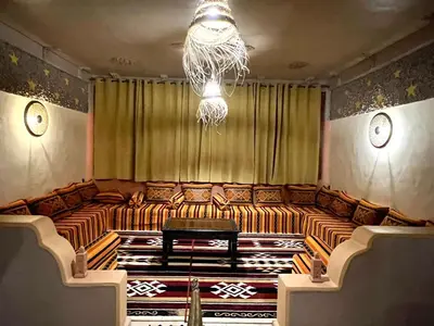 a room with a large couch with a chandelier at Riad Merzouga Dunes in Merzouga