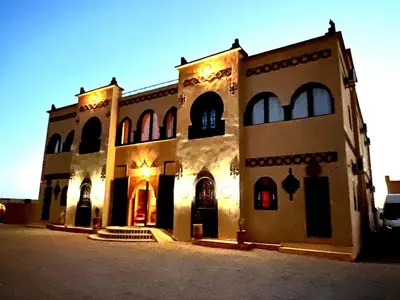 a large building with lights on the front of it at Riad Merzouga Dunes in Merzouga