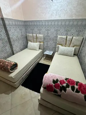 two beds in a room with flowers on them at A appartement in Fès
