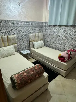 a room with two beds and a couch in it at A appartement in Fès