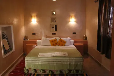 a bedroom with a bed with two pillows on it at Maison Hassan Merzouga in Merzouga