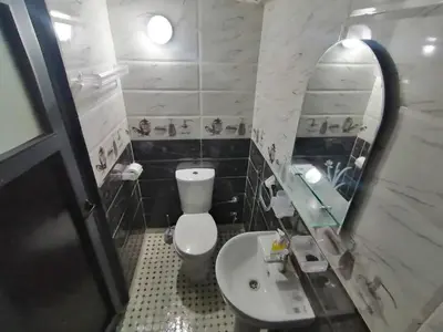 a bathroom with a toilet and a sink and a mirror at Appart Artisanal sur Fez in Fès