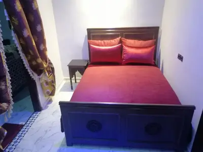 a bedroom with a bed with two pink pillows at Appart Artisanal sur Fez in Fès