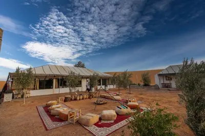 a building with a playground in the middle of a field at Jouba Luxury Camp in Merzouga