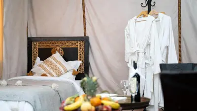 a room with a bed and a table with fruit at Jouba Luxury Camp in Merzouga