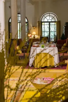 a dining room with a table and chairs and windows at Auberge Ksar Jallal in Ksar Oled Cherki