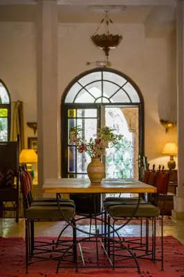 a table and chairs with a vase on top of it at Auberge Ksar Jallal in Ksar Oled Cherki