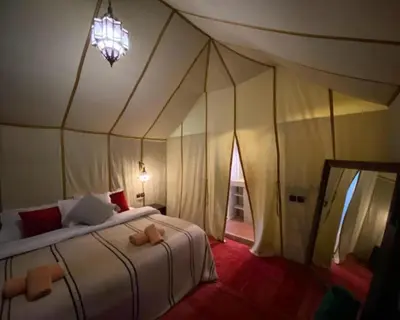 a bedroom with a bed in a tent at spirit desert camp in Merzouga