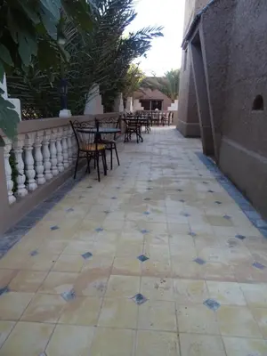 a walkway with tables and chairs on a patio at PALM'SKOURA in Skoura