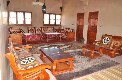 a living room with wooden furniture and a table at PALM'SKOURA in Skoura