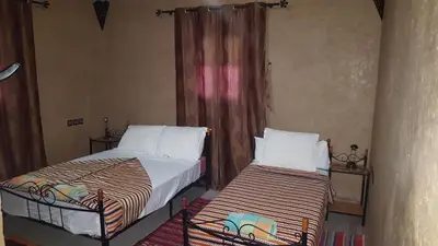 a bedroom with two beds and a window at PALM'SKOURA in Skoura