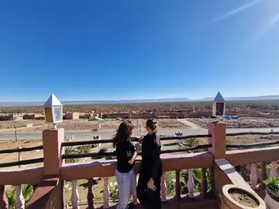 two women standing on a fence looking out at the desert at Kasbah of Peace Draa Valley Zagora in Zagora