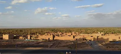 a village in the middle of a desert with buildings at Kasbah of Peace Draa Valley Zagora in Zagora
