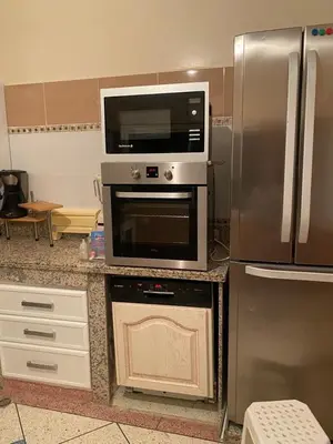 a kitchen with a microwave and a refrigerator at Appartement Yasin Meknes in Meknès