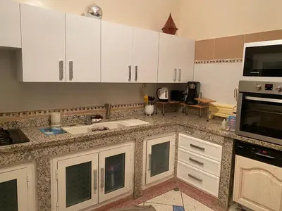 a kitchen with white cabinets and a microwave at Appartement Yasin Meknes in Meknès