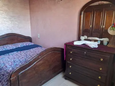 a bedroom with a wooden bed and a dresser at Appartement au centre de la ville de Meknès in Meknès