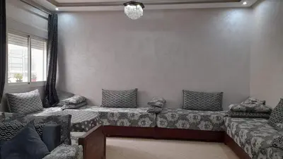 a living room with two beds and a window at Appartement au centre de la ville de Meknès in Meknès