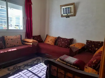 a living room with red couches and a window at Appartement au centre de la ville de Meknès in Meknès