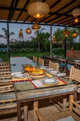a wooden table with plates of food on it at Al Destino Villa Riad Spa Luxury Marrakech in Marrakech