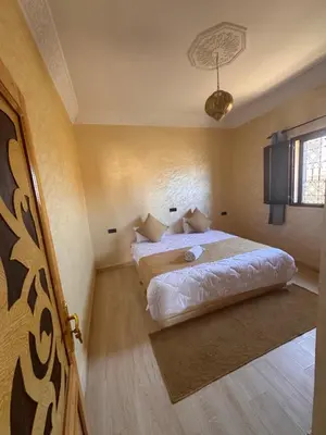 a bedroom with a bed in the corner of a room at Dar Amrad in Merzouga