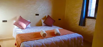 a bedroom with a bed with shoes on it at Dar Amrad in Merzouga