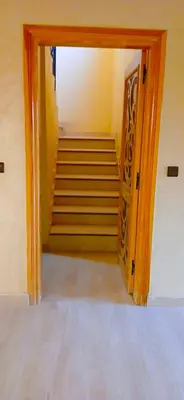 a hallway with a stairway with a door and stairs at Dar Amrad in Merzouga