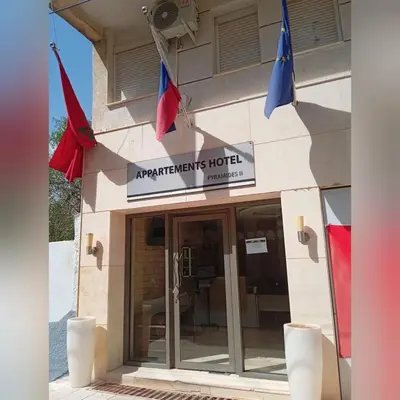 a hotel with flags hanging outside of it at APPARTEMENTS HOTEL PYRAMIDES in Taza