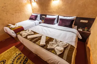 two beds in a room with towels on them at Palais Ksar Lamane in Aït Ben Haddou