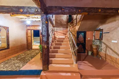 a staircase in a house with a stone wall at Palais Ksar Lamane in Aït Ben Haddou