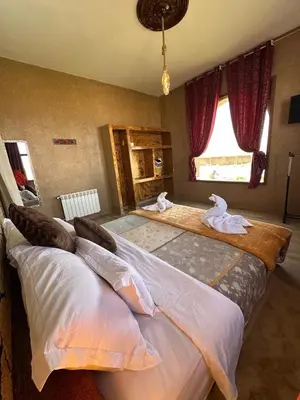 a bedroom with two beds with towels on them at DAR AL QANASS IMANE in Midelt