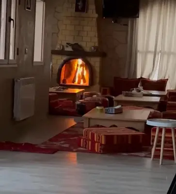 a living room with a fire oven in the background at DAR AL QANASS IMANE in Midelt