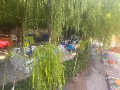 a view of a yard with tables and chairs at Hôtel Restaurant ASGAOUR in Amlouggui