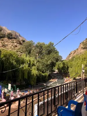 a balcony with a view of a river and mountains at Hôtel Restaurant ASGAOUR in Amlouggui