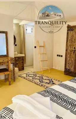 a room with two beds and a sign on the wall at Tranquility Luxury Camp in Merzouga