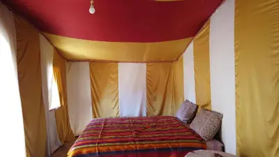 a bedroom with a bed in a tent at Camp Sahara Dunes in Mhamid