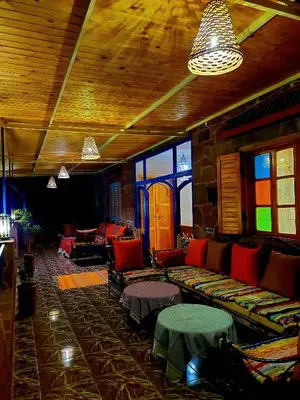 a living room with a couch and chairs and windows at DAR EL HACHIMI EL IDRISSI in Ourika