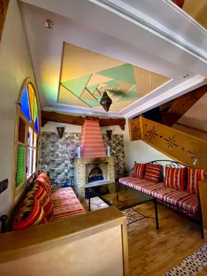a living room with a couch and a fireplace at DAR EL HACHIMI EL IDRISSI in Ourika