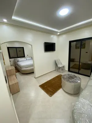 a large room with two beds and a tv at Le ruban d’or in Azilal