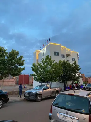 a building with cars parked in a parking lot at Le ruban d’or in Azilal