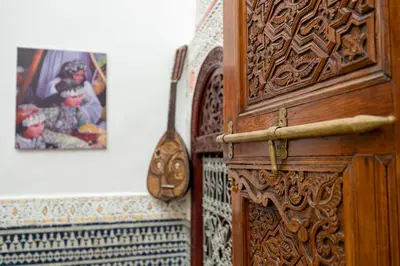a wooden door in a room with a picture on the wall at Riad Tarab Fes in Fès