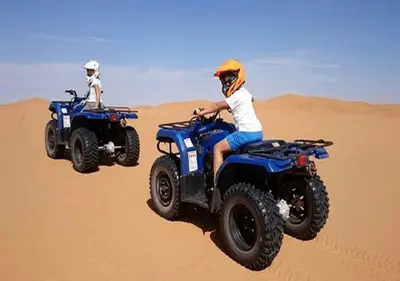 two people riding on atvs in the desert at Safari luxury desert camp in Merzouga