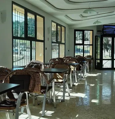a row of tables and chairs in a room with windows at TAZEKKA PARC HOTEL in Taza