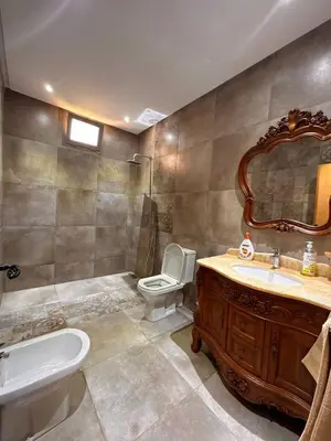 a bathroom with a sink and a toilet and a mirror at Dar HAKIM piscine privée in Marrakech