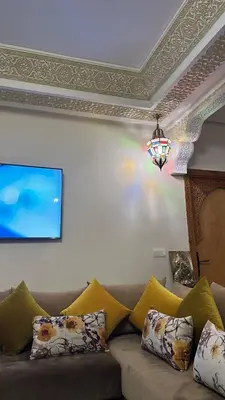 a living room with a couch with pillows at Dar HAKIM piscine privée in Marrakech