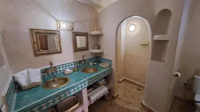 a bathroom with two sinks and a shower at Dar S'BAH in Fès